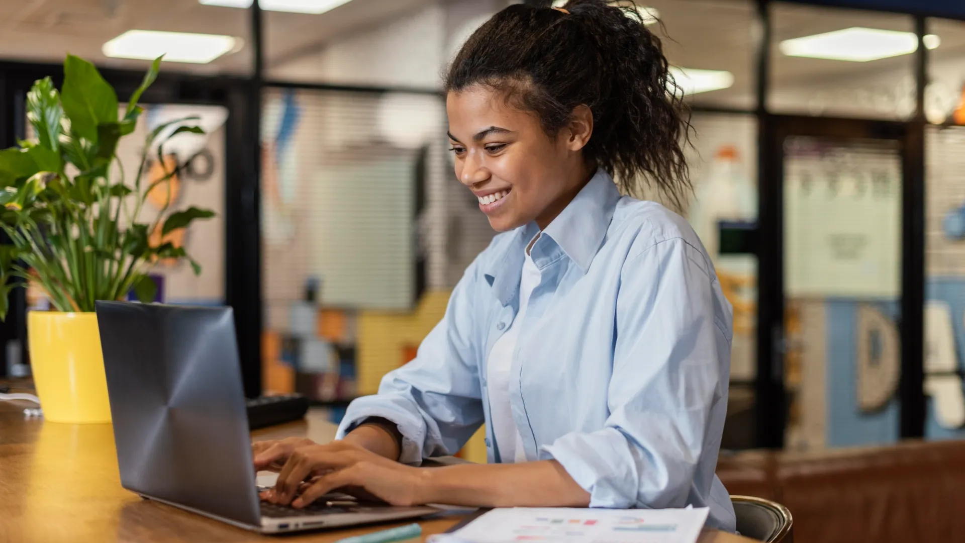 Mulher negra trabalhando em frente a um notebook